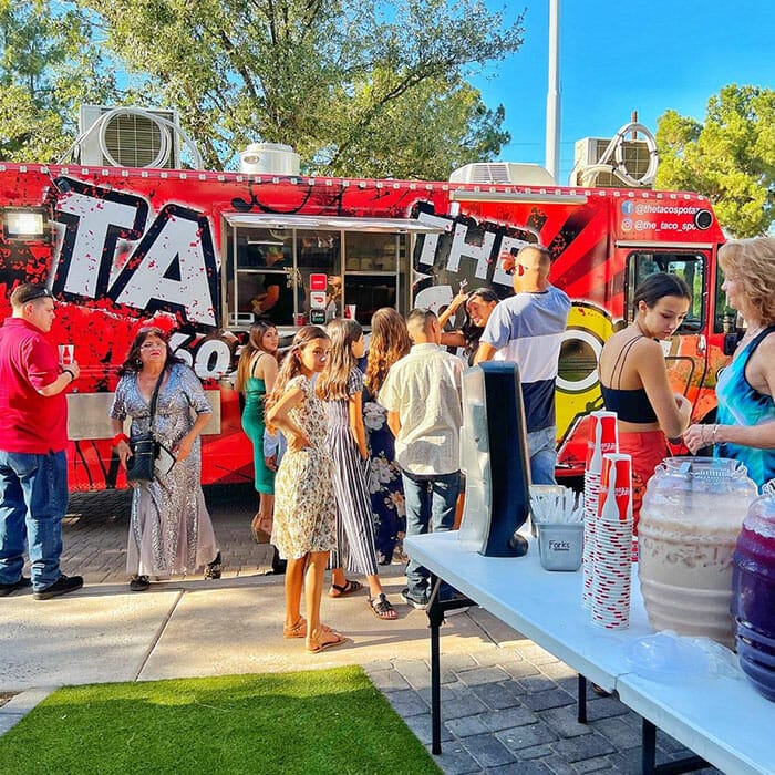 A group of people standing around a food truck.
