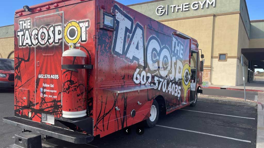 The Taco Spot Food Truck is parked in front of a building.