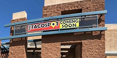 Building exterior with a sign reading "The Taco Spot Coming Soon.